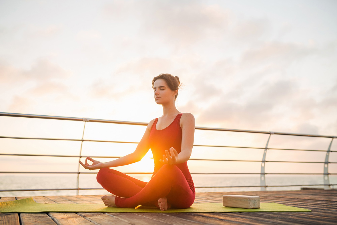 Yoga practitioner holding mat in soft natural light